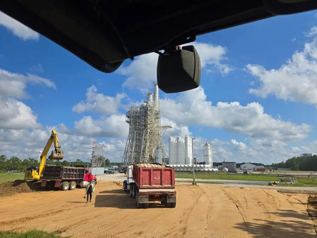 Dump trucks and excavator at a Rocket Engine Test Stand worksite at John C. Stennis Space Center