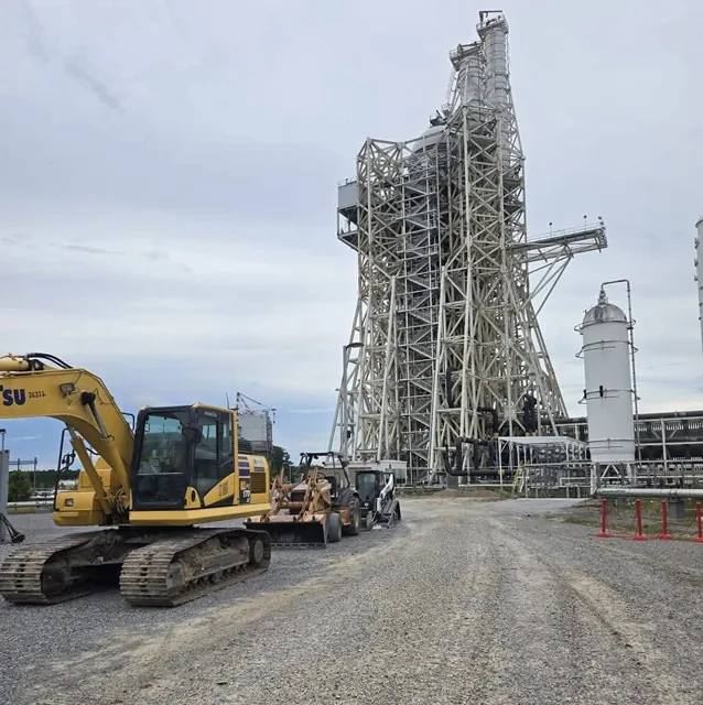 Excavators and transport equipment beside a Rocket Engine Test Stand at John C. Stennis Space Center